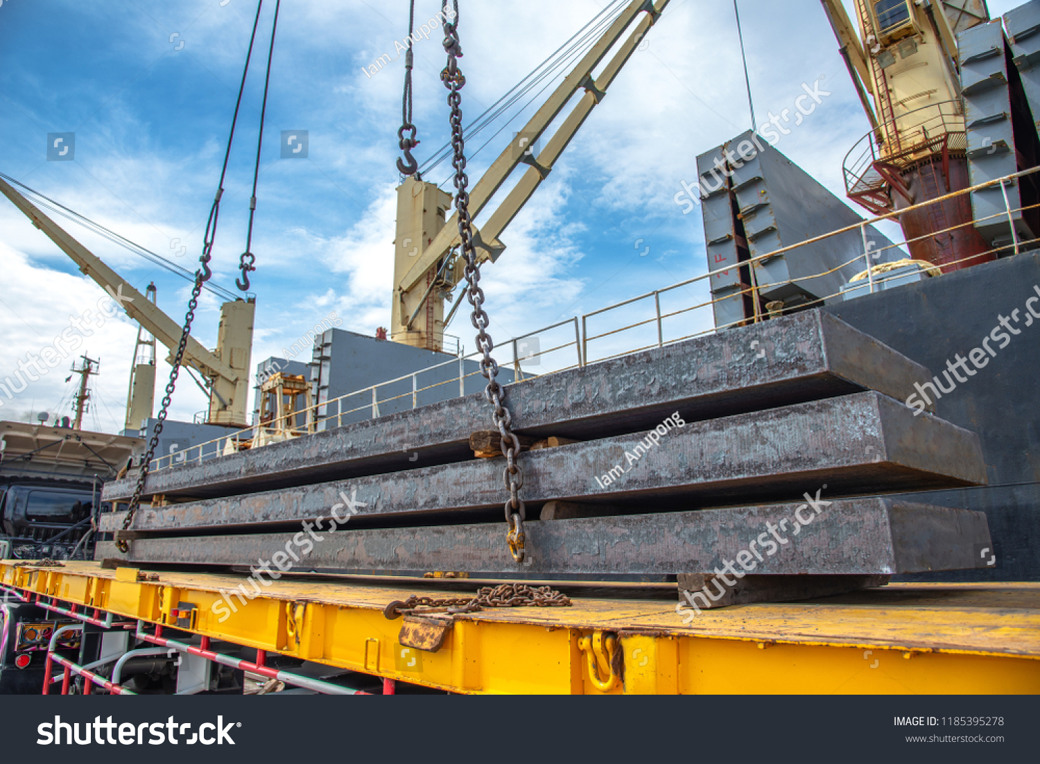 stock-photo-bundle-of-steel-slabs-being-loading-discharging-in-port-terminal-laying-onto-base-of-trailer-1185395278